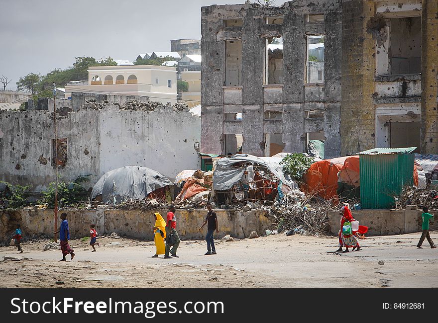 Civilians walk past bombed-out and destroyed buildings in the Boondheere district of the Somali capital Mogadishu, 05 August, 2013. 06 August marks 2 years since the Al Qaeda-affiliated extremist group Al Shabaab withdrew from Mogadishu following sustained operations by forces of the Somali National Army &#x28;SNA&#x29; backed by troops of the African Union Mission in Somalia &#x28;AMISOM&#x29; to retake the city. Since the group&#x27;s departure the country&#x27;s captial has re-established itself and a sense of normality has returned. Buildings and infrastructure devastated and destroyed by two decades of conflict have been repaired; thousands of Diaspora Somalis have returned home to invest and help rebuild their nation; foreign embassies and diplomatic missions have reopened and for the first time in many years, Somalia has an internationally recognised government.. AU-UN IST PHOTO / STUART PRICE. Civilians walk past bombed-out and destroyed buildings in the Boondheere district of the Somali capital Mogadishu, 05 August, 2013. 06 August marks 2 years since the Al Qaeda-affiliated extremist group Al Shabaab withdrew from Mogadishu following sustained operations by forces of the Somali National Army &#x28;SNA&#x29; backed by troops of the African Union Mission in Somalia &#x28;AMISOM&#x29; to retake the city. Since the group&#x27;s departure the country&#x27;s captial has re-established itself and a sense of normality has returned. Buildings and infrastructure devastated and destroyed by two decades of conflict have been repaired; thousands of Diaspora Somalis have returned home to invest and help rebuild their nation; foreign embassies and diplomatic missions have reopened and for the first time in many years, Somalia has an internationally recognised government.. AU-UN IST PHOTO / STUART PRICE.