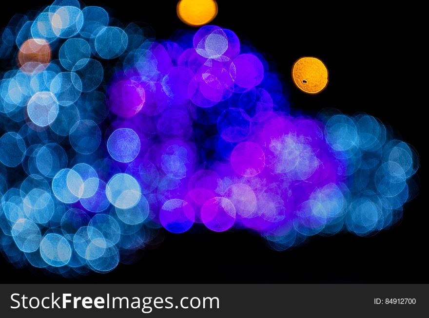 Blue and purple bokeh lights shining with black background.