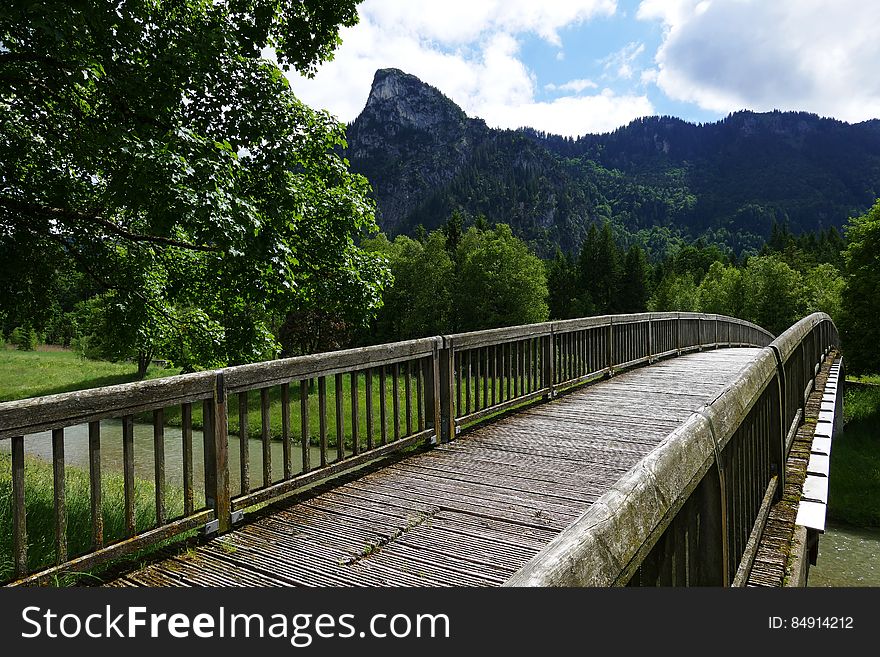 A bridge crossing a river with mountains in the distance. A bridge crossing a river with mountains in the distance.