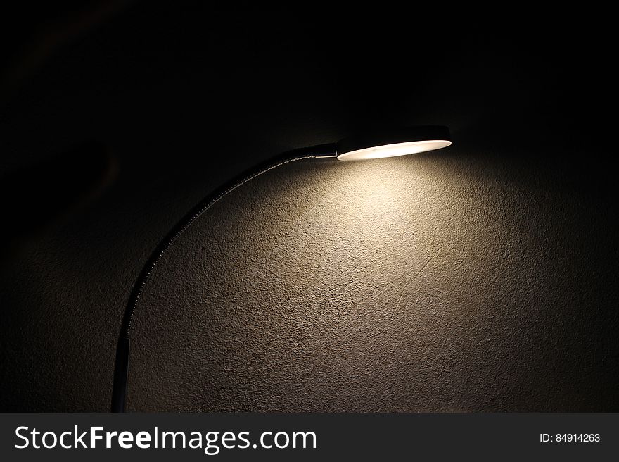 A table lamp shining light in the dark.