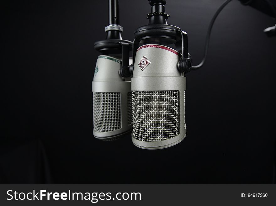 A pair of professional microphones on a black background.