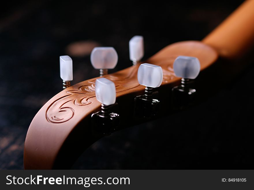 Classic guitar head and tuning pegs with artistic engraving.