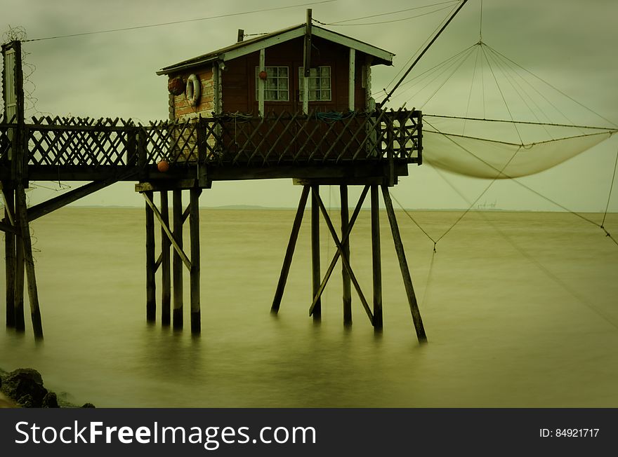 Boathouse on end of wooden dock with fishing nets. Boathouse on end of wooden dock with fishing nets.