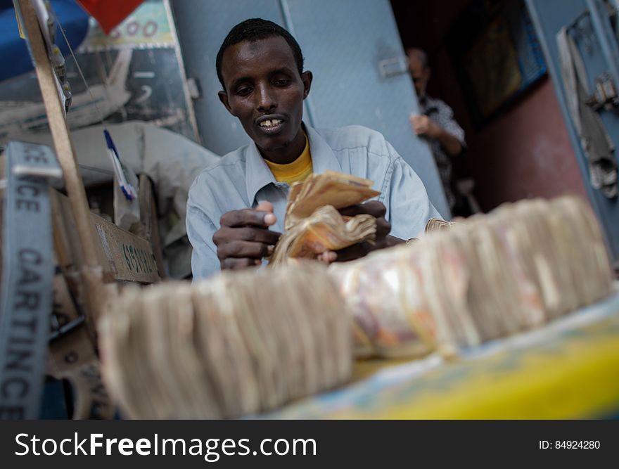 A money exchanger counts Somali shilling notes on the streets of the Somali capital Mogadishu. Millions of people in the Horn of Africa nation Somalia rely on money sent from their relatives and friends abroad in the form of remittances in order to survive, but it is feared that a decision by Barclays Bank to close the accounts of some of the biggest Somali money transfer firms â€“ due to be announced this week - will have a devastating effect on the country and its people. According to the United Nations Development Programme &#x28;UNDP&#x29;, an estimated $1.6 billion US dollars is sent back annually by Somalis living in Europe and North America. Some money transfer companies in Somalia have been accused of being used by pirates to launder money received form ransoms as well as used by Al Qaeda-affiliated extremist group al Shabaab group to fund their terrorist activities and operations in Somalia and the wider East African region. AU/UN IST PHOTO / STUART PRICE. A money exchanger counts Somali shilling notes on the streets of the Somali capital Mogadishu. Millions of people in the Horn of Africa nation Somalia rely on money sent from their relatives and friends abroad in the form of remittances in order to survive, but it is feared that a decision by Barclays Bank to close the accounts of some of the biggest Somali money transfer firms â€“ due to be announced this week - will have a devastating effect on the country and its people. According to the United Nations Development Programme &#x28;UNDP&#x29;, an estimated $1.6 billion US dollars is sent back annually by Somalis living in Europe and North America. Some money transfer companies in Somalia have been accused of being used by pirates to launder money received form ransoms as well as used by Al Qaeda-affiliated extremist group al Shabaab group to fund their terrorist activities and operations in Somalia and the wider East African region. AU/UN IST PHOTO / STUART PRICE.