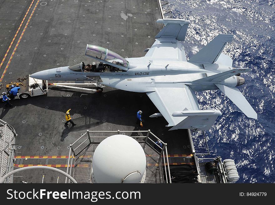 Sailors transport a Boeing EA-18G &#x22;Growler&#x22; assigned to the &#x27;Gauntlets&#x27; of Electronic Attack Squadron &#x28;VAQ&#x29; 136 onto an aircraft elevator aboard the USS Ronald Reagan &#x28;CVN 76&#x29;. Ronald Reagan is en route to Hawaii for Rim of the Pacific &#x28;RIMPAC&#x29; 2014. Twenty-three nations, more than 40 ships and submarines, more than 200 aircraft and 25,000 personnel are participating in the biennial RIMPAC exercise from June 26 to Aug. 1-un-edited-Not part of my personal collection