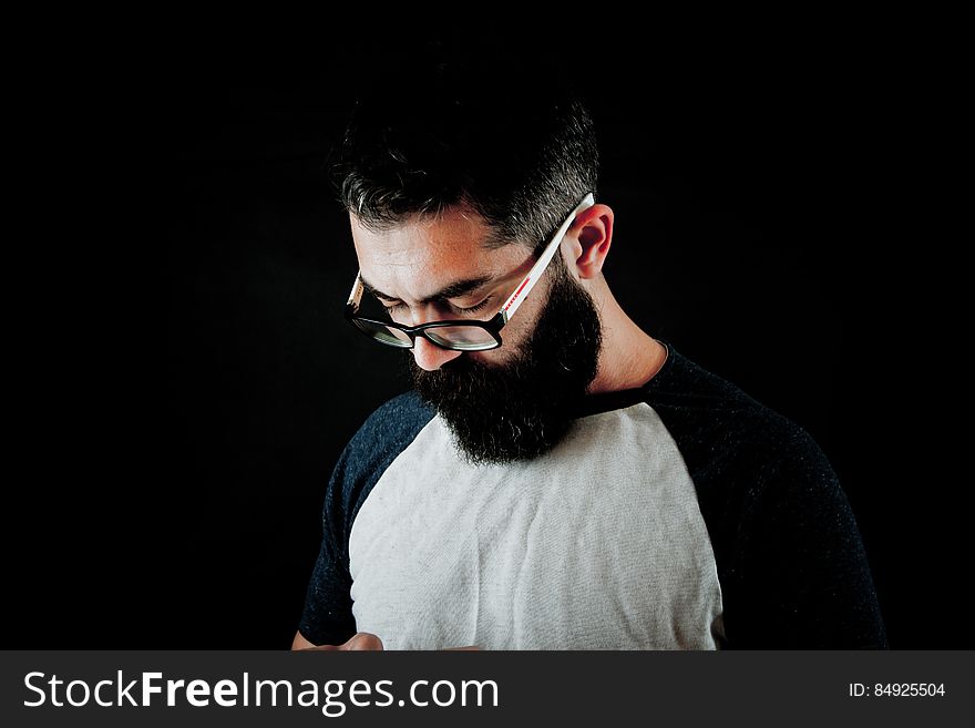 Studio portrait of man with beard wearing glasses with serious expression. Studio portrait of man with beard wearing glasses with serious expression.