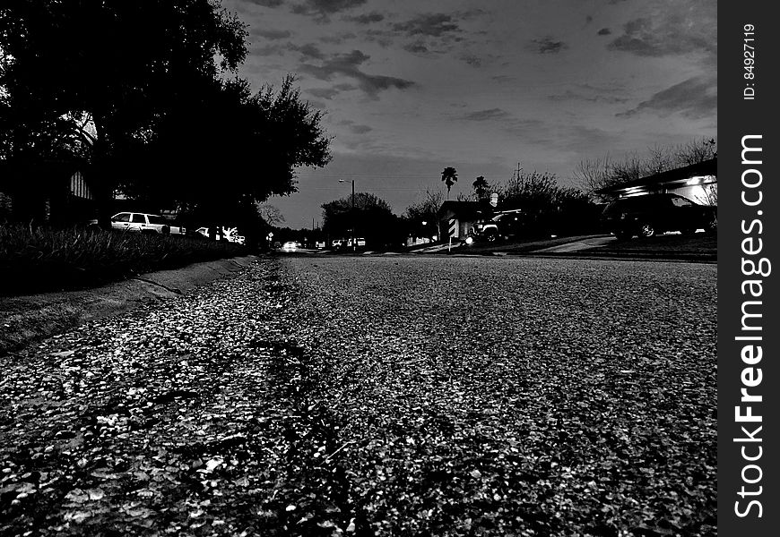 Neighborhood street at night in black and white.