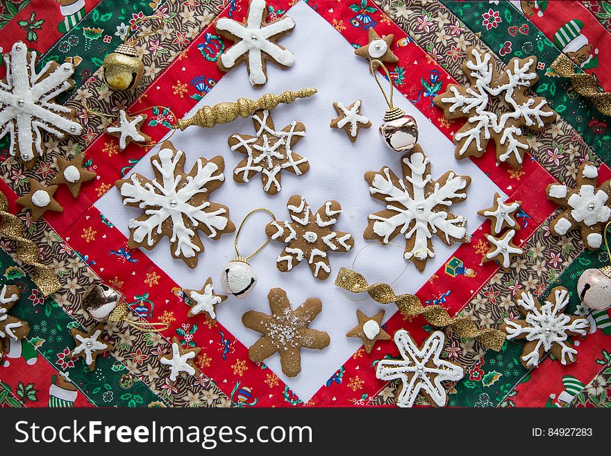 Decorated gingerbread snowflake cookies and Christmas ornaments on colorful quilt. Decorated gingerbread snowflake cookies and Christmas ornaments on colorful quilt.