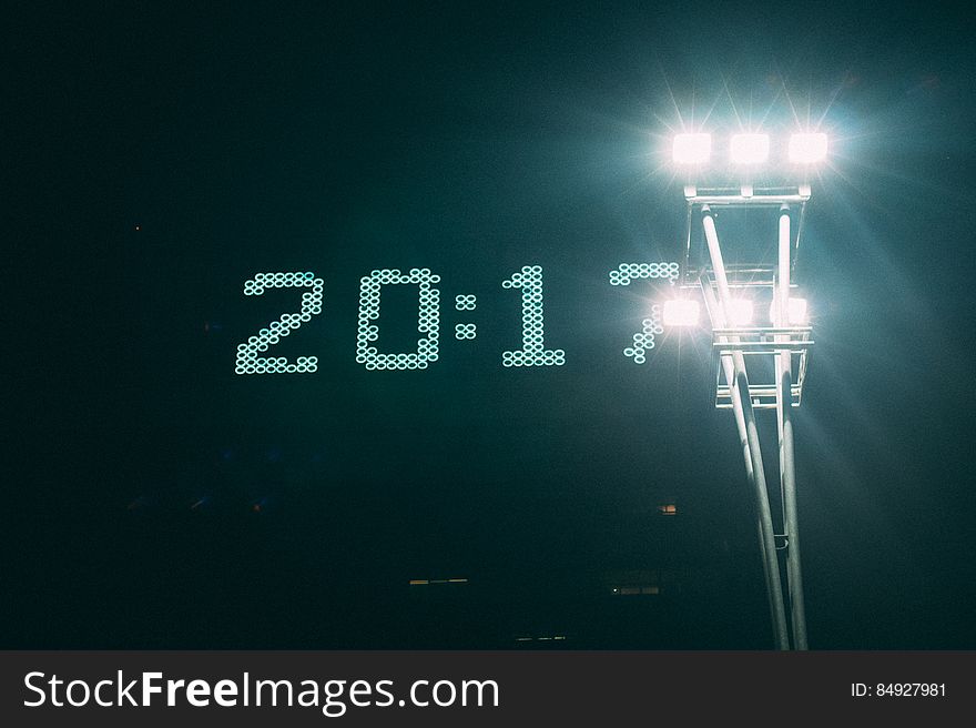 Digital clock sign at night showing 2017 next to shining floodlights. Digital clock sign at night showing 2017 next to shining floodlights.