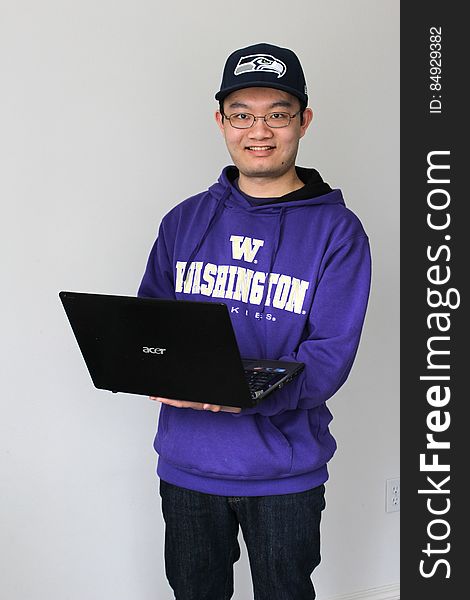 Photo of a person posing with a laptop. Photo of a person posing with a laptop.