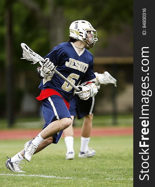 Man in Blue and White Jersey Playing Lacrosse