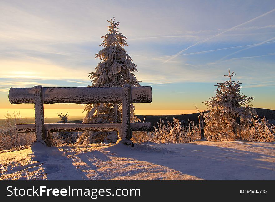 Snow Covered Bench on Mountain Top during Sunset