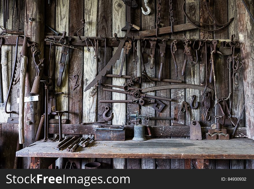 Black Metal Tools Hanged on a Rack Near Table