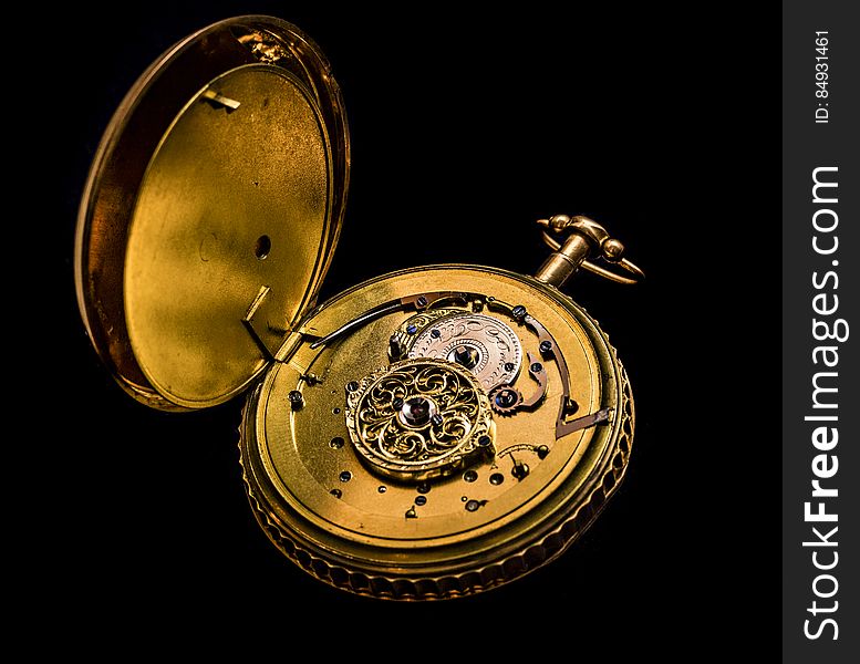 Antique gold pocket watch open to gear workings, isolated on a black background. Antique gold pocket watch open to gear workings, isolated on a black background.