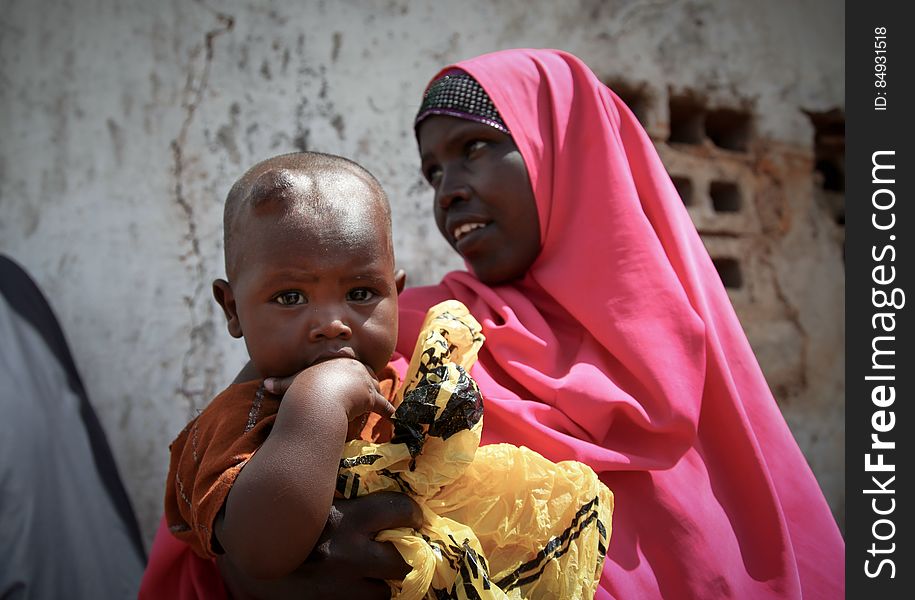 A women and her young child wait in the shade of a derelict building to see a doctor at a free medical clinic provided by the Kenyan Contingent serving with the African Union Mission in Somalia &#x28;AMISOM&#x29; in the southern Somali port city of Kismayo, 19 August 2013. Open 7 days a week and seeing an average of 80 patients a day from Kismayo and surrounding villages, AMISOM medical staff provide the free health care to Kismayo&#x27;s civilians, treating a variety of cases including malaria, respiratry tract infections, sexually transmitted infections and occassionally gunshot wounds. AU-UN IST PHOTO / RAMADAAN MOHAMED HASSAN. A women and her young child wait in the shade of a derelict building to see a doctor at a free medical clinic provided by the Kenyan Contingent serving with the African Union Mission in Somalia &#x28;AMISOM&#x29; in the southern Somali port city of Kismayo, 19 August 2013. Open 7 days a week and seeing an average of 80 patients a day from Kismayo and surrounding villages, AMISOM medical staff provide the free health care to Kismayo&#x27;s civilians, treating a variety of cases including malaria, respiratry tract infections, sexually transmitted infections and occassionally gunshot wounds. AU-UN IST PHOTO / RAMADAAN MOHAMED HASSAN.