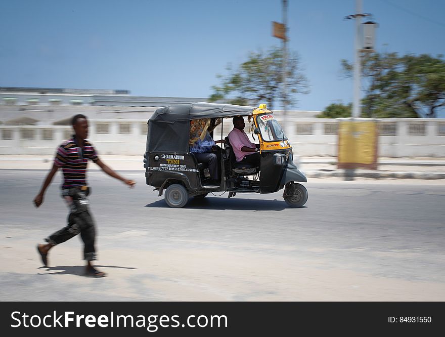 A 3-wheeled motorised taxi known as a &#x27;Tuk-Tuk&#x27; carries a passenger through thes treets of the Somali capital Mogadishu, 01 September 2013. Of one of many new modes of transport for people in Mogadishu, the Mogadishu Taxi Company has been operating since the end of May of this year in the city&#x27;s dusty and once again bustling streets and thoroughfares. The MTC&#x27;s distinctive yellow and purple cars offer customers taxi fares around Mogadishu at competitive rates and in the first 3 months of operations, the company has increased it&#x27;s fleet of vehicles from an initial 25 to over 100. The company, according to one of it&#x27;s drivers, also enables employment opportunities for Somalia&#x27;s youth following two decades of conflict in the Horn of Africa nation that shattered a generation. Now, thanks to the relative peace that has followed the departure of the Al-Qaeda-affiliated extremist group Al Shabaab from the city; an internationally recognised government for the first time in years and thousands of Diaspora Somalis returning home to invest in and rebuild their country, the MTC is one of many new companies establishing itself in the new Mogadishu and offering services that were hitherto impossible to provide. AU-UN IST PHOTO / STUART PRICE. A 3-wheeled motorised taxi known as a &#x27;Tuk-Tuk&#x27; carries a passenger through thes treets of the Somali capital Mogadishu, 01 September 2013. Of one of many new modes of transport for people in Mogadishu, the Mogadishu Taxi Company has been operating since the end of May of this year in the city&#x27;s dusty and once again bustling streets and thoroughfares. The MTC&#x27;s distinctive yellow and purple cars offer customers taxi fares around Mogadishu at competitive rates and in the first 3 months of operations, the company has increased it&#x27;s fleet of vehicles from an initial 25 to over 100. The company, according to one of it&#x27;s drivers, also enables employment opportunities for Somalia&#x27;s youth following two decades of conflict in the Horn of Africa nation that shattered a generation. Now, thanks to the relative peace that has followed the departure of the Al-Qaeda-affiliated extremist group Al Shabaab from the city; an internationally recognised government for the first time in years and thousands of Diaspora Somalis returning home to invest in and rebuild their country, the MTC is one of many new companies establishing itself in the new Mogadishu and offering services that were hitherto impossible to provide. AU-UN IST PHOTO / STUART PRICE.