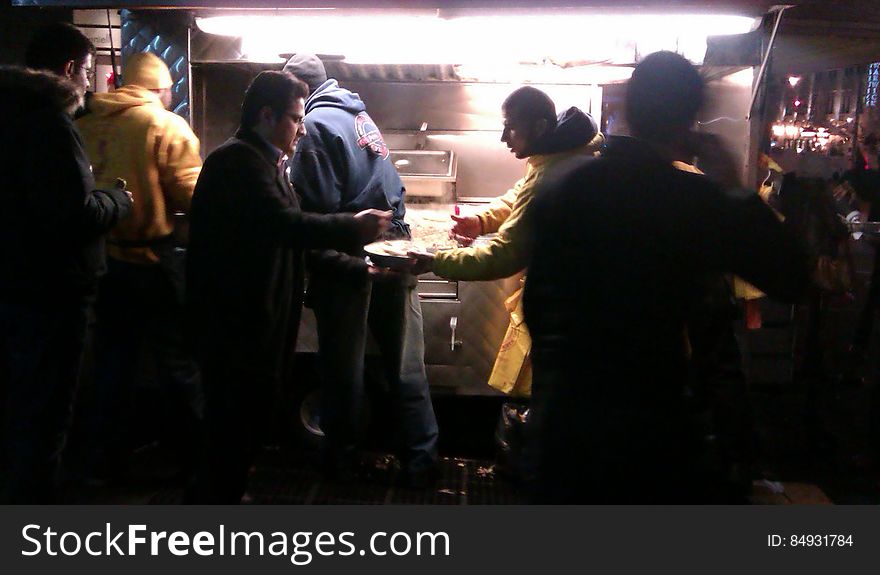 Diners at table outside food truck at night. Diners at table outside food truck at night.