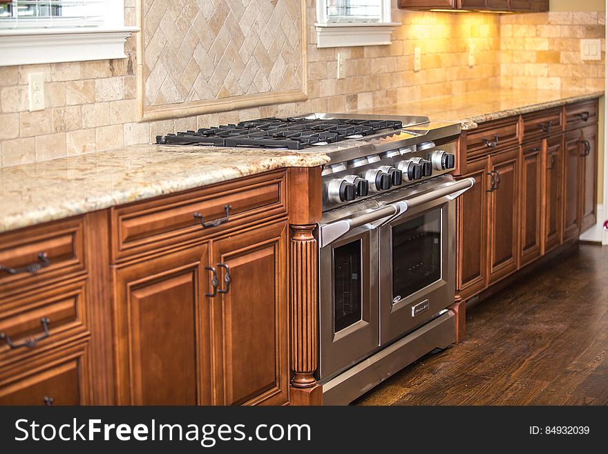 Fancy designer kitchen with large stove and oven and warm wood cabinets. Fancy designer kitchen with large stove and oven and warm wood cabinets.