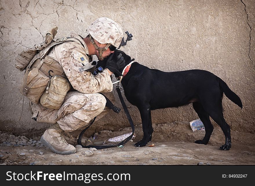 Soldier And Black Dog Cuddling