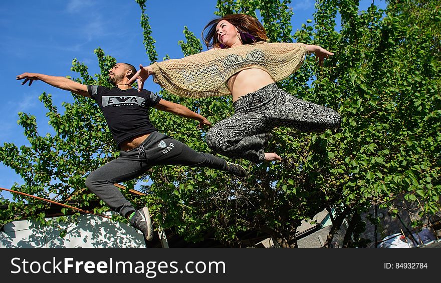 Woman In Black And Grey Pants Beside Man In Black Gap Pants Surrounded By Trees