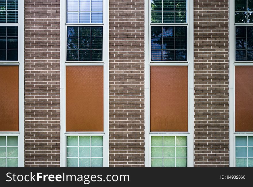 Exterior of a brick building with windows. Vertical stripe pattern. Exterior of a brick building with windows. Vertical stripe pattern.