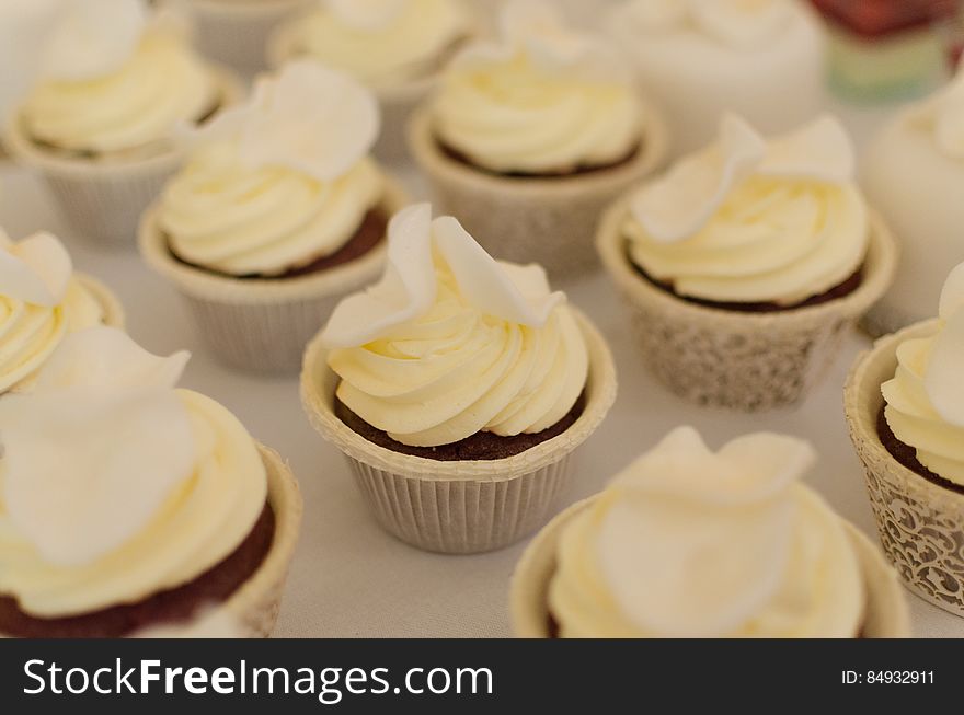Vanilla swirl frosted cupcakes in decorative paper liners.