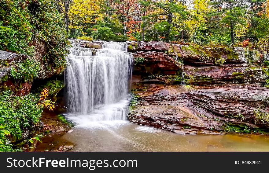 Waterfall over flat rocks in the autumn forest. Waterfall over flat rocks in the autumn forest.