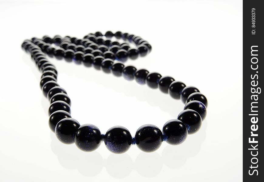 A black pearl necklace on white background. A black pearl necklace on white background.