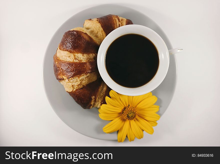 A cup of coffee and a croissant. A cup of coffee and a croissant.