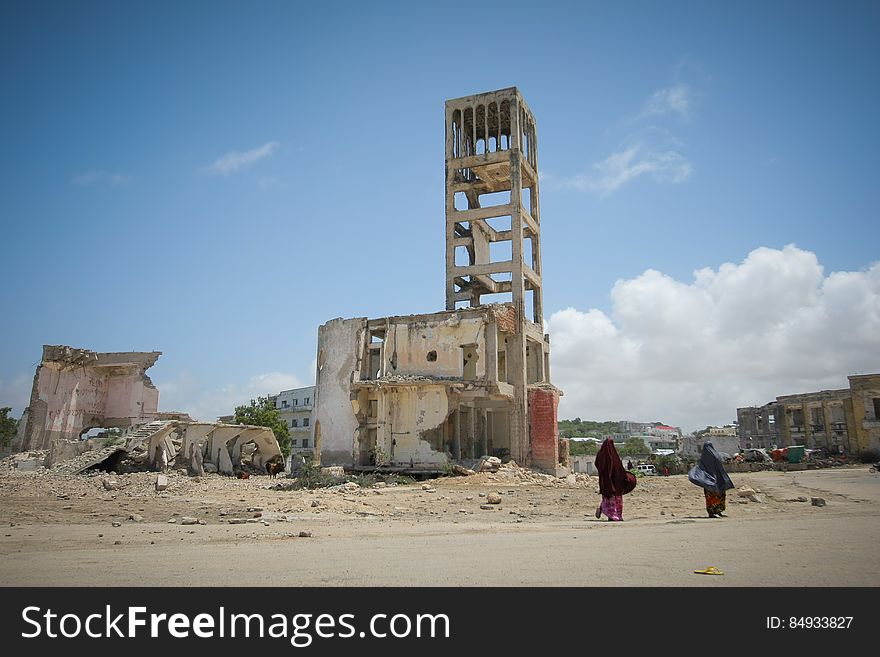 Two women walk past bombed-out and destroyed buildings in the Boondheere district of the Somali capital Mogadishu, 05 August, 2013. 06 August marks 2 years since the Al Qaeda-affiliated extremist group Al Shabaab withdrew from Mogadishu following sustained operations by forces of the Somali National Army &#x28;SNA&#x29; backed by troops of the African Union Mission in Somalia &#x28;AMISOM&#x29; to retake the city. Since the group&#x27;s departure the country&#x27;s captial has re-established itself and a sense of normality has returned. Buildings and infrastructure devastated and destroyed by two decades of conflict have been repaired; thousands of Diaspora Somalis have returned home to invest and help rebuild their nation; foreign embassies and diplomatic missions have reopened and for the first time in many years, Somalia has an internationally recognised government.. AU-UN IST PHOTO / STUART PRICE. Two women walk past bombed-out and destroyed buildings in the Boondheere district of the Somali capital Mogadishu, 05 August, 2013. 06 August marks 2 years since the Al Qaeda-affiliated extremist group Al Shabaab withdrew from Mogadishu following sustained operations by forces of the Somali National Army &#x28;SNA&#x29; backed by troops of the African Union Mission in Somalia &#x28;AMISOM&#x29; to retake the city. Since the group&#x27;s departure the country&#x27;s captial has re-established itself and a sense of normality has returned. Buildings and infrastructure devastated and destroyed by two decades of conflict have been repaired; thousands of Diaspora Somalis have returned home to invest and help rebuild their nation; foreign embassies and diplomatic missions have reopened and for the first time in many years, Somalia has an internationally recognised government.. AU-UN IST PHOTO / STUART PRICE.