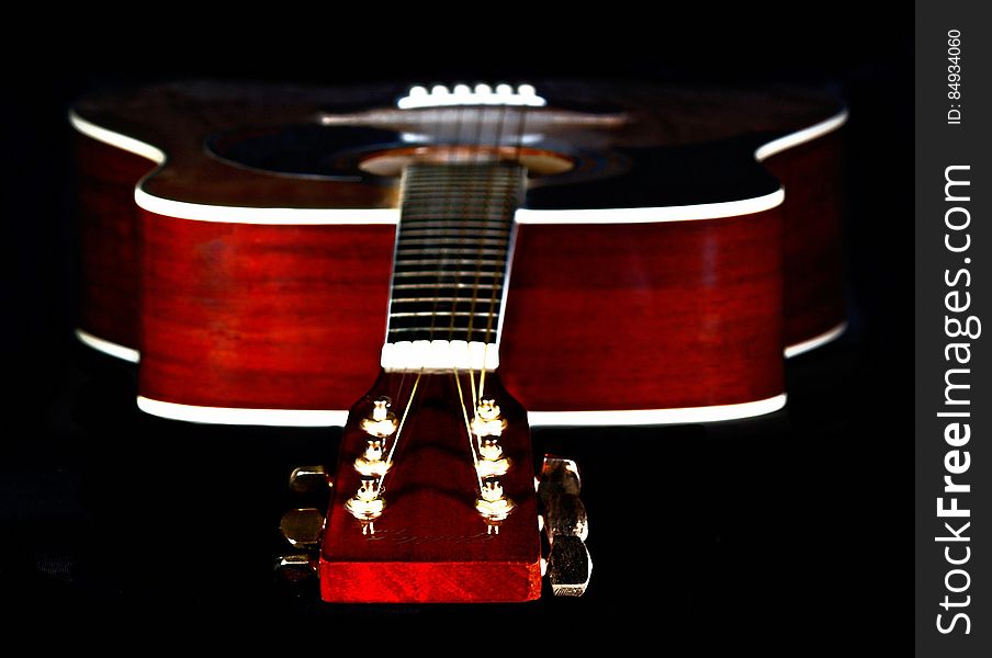 Close Up Photography of Red Wooden Guitar Head Stock