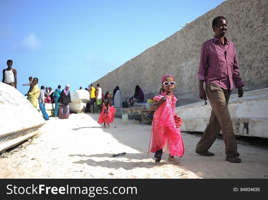 A little girl and her father walk on Lido beach in Mogadishu, Somalia, during Eid al-Fitr on July 28. AMISOM Photo / Tobin Jones. A little girl and her father walk on Lido beach in Mogadishu, Somalia, during Eid al-Fitr on July 28. AMISOM Photo / Tobin Jones