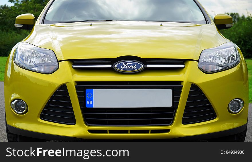 Front view of a yellow Ford motor car.