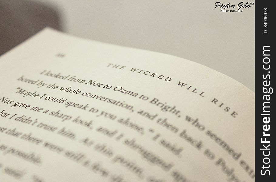 Closeup of a page from a best selling book entitled, "The wicked will rise" using selective focus on the title, cream background.
