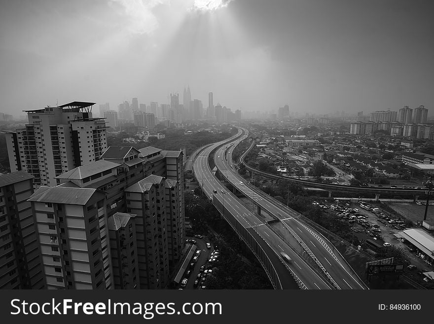 A black and white panoramic view of a highway through a city. A black and white panoramic view of a highway through a city.