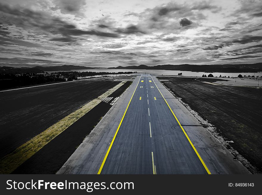 An aerial view of an empty runway near a coast. An aerial view of an empty runway near a coast.