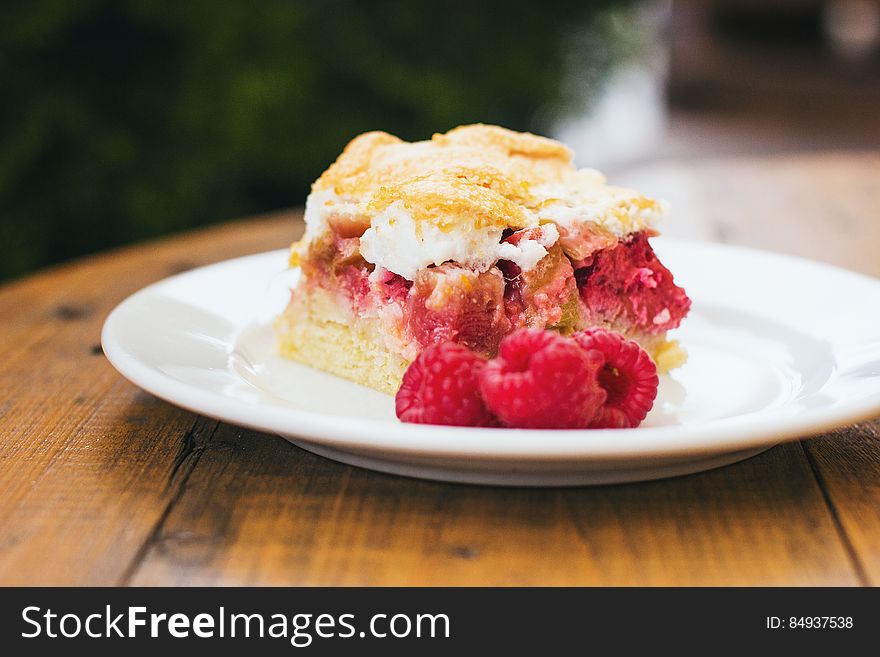 A cake with raspberry filling and meringue on top. A cake with raspberry filling and meringue on top.