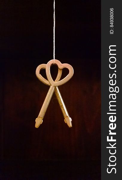 A close up of a hanging pair of heart shaped keys. A close up of a hanging pair of heart shaped keys.