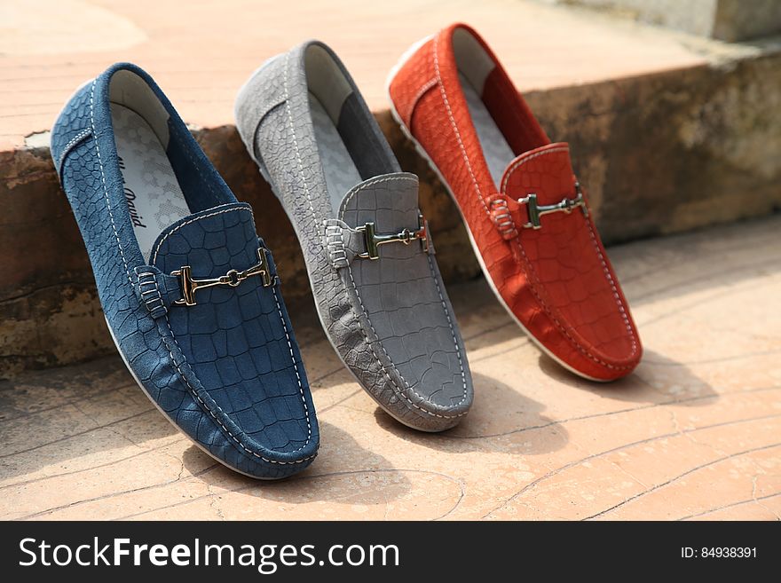 Three different colored fashionable men's leather shoes on wooden floor. Three different colored fashionable men's leather shoes on wooden floor.