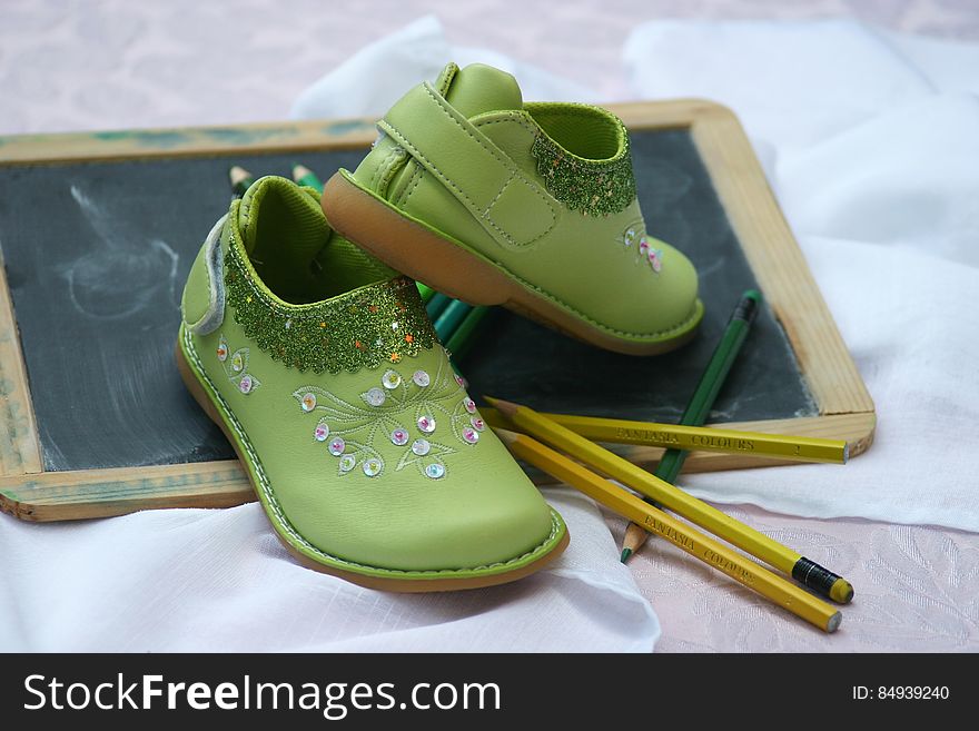 Green Slip on Shoes Near Yellow and Green Pencil