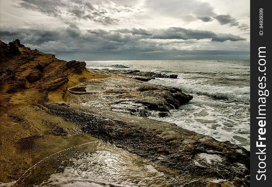 A view across a rocky coast with cloudy skies.