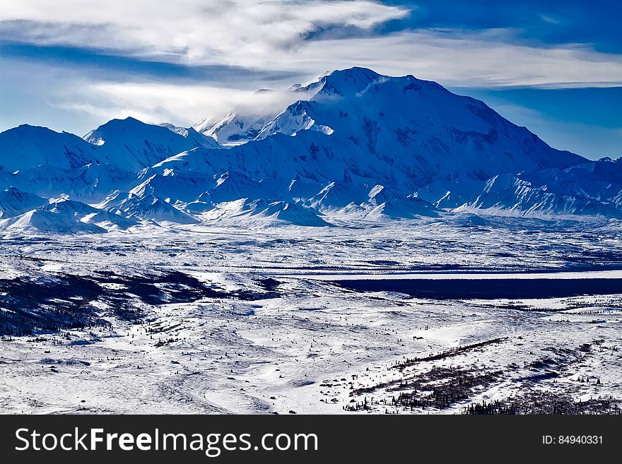 A mountain range and a valley below covered in snow. A mountain range and a valley below covered in snow.