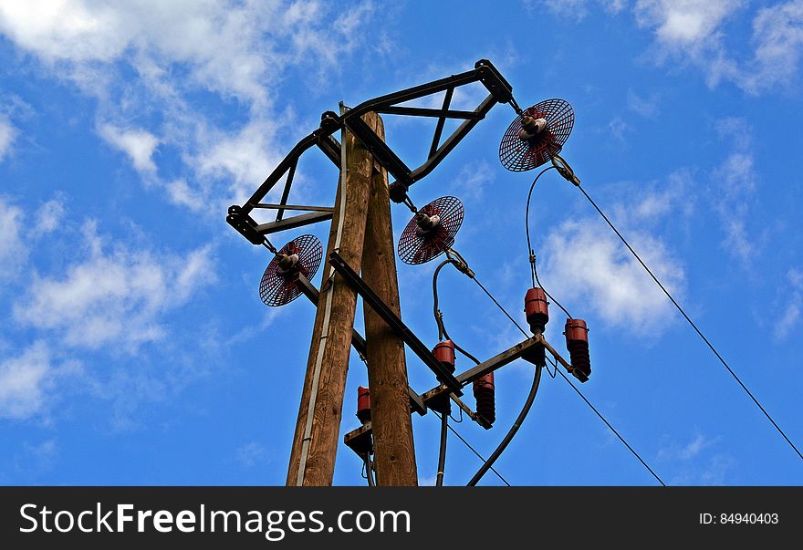 An overhead power line attached to a wooden pole.