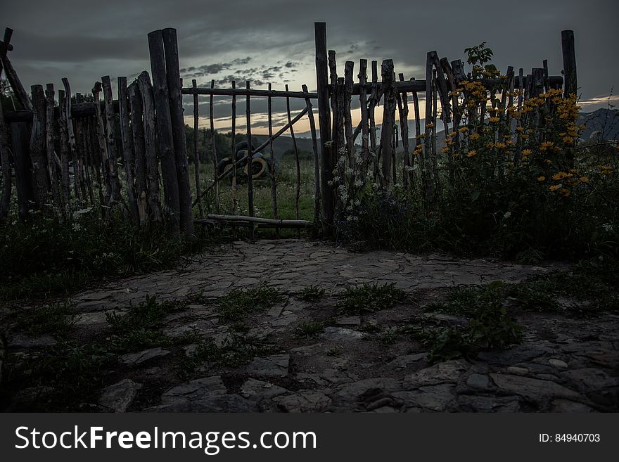 A countryside fence with flowers and rustic gate. A countryside fence with flowers and rustic gate.