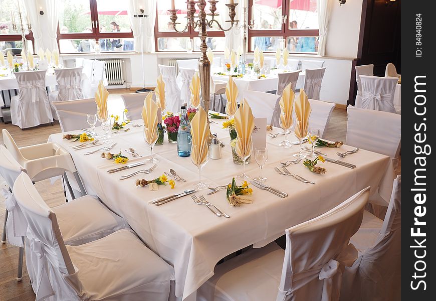 A table setting for party with white tablecloths. A table setting for party with white tablecloths.