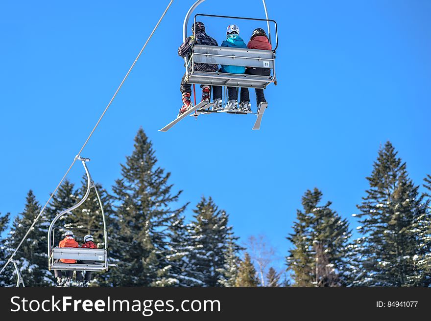 Skiers on a ski lift in a skiing resort.
