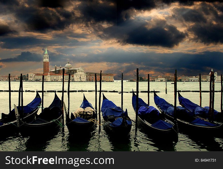 Canoes Docked In Water Near Concrete Structures