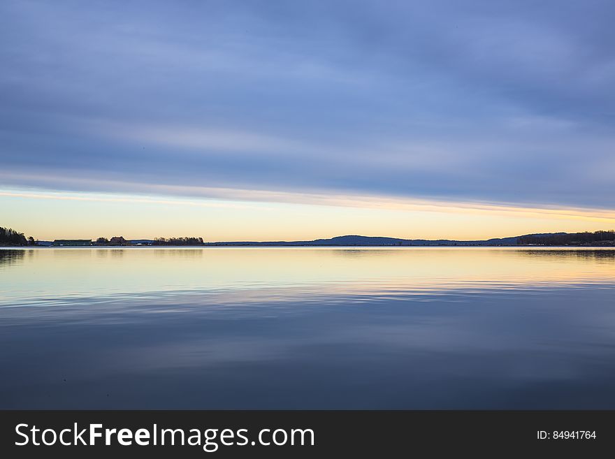 A calm lake reflecting the sunset skies above. A calm lake reflecting the sunset skies above.