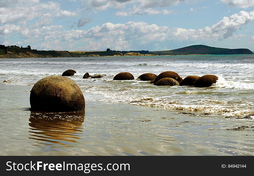 The Moeraki Boulders are geological marvels, exposed by erosion of sedimentary rocks laid down from 65 to 13 million years ago. They are formed by the gradual precipitation of calcite in mudstone over 4 million years. These spherical concretions are internationally significant for their scientific value and are a popular tourist attraction. The Moeraki Boulders are geological marvels, exposed by erosion of sedimentary rocks laid down from 65 to 13 million years ago. They are formed by the gradual precipitation of calcite in mudstone over 4 million years. These spherical concretions are internationally significant for their scientific value and are a popular tourist attraction.