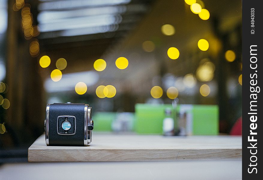 An old film camera on table with defocused background.